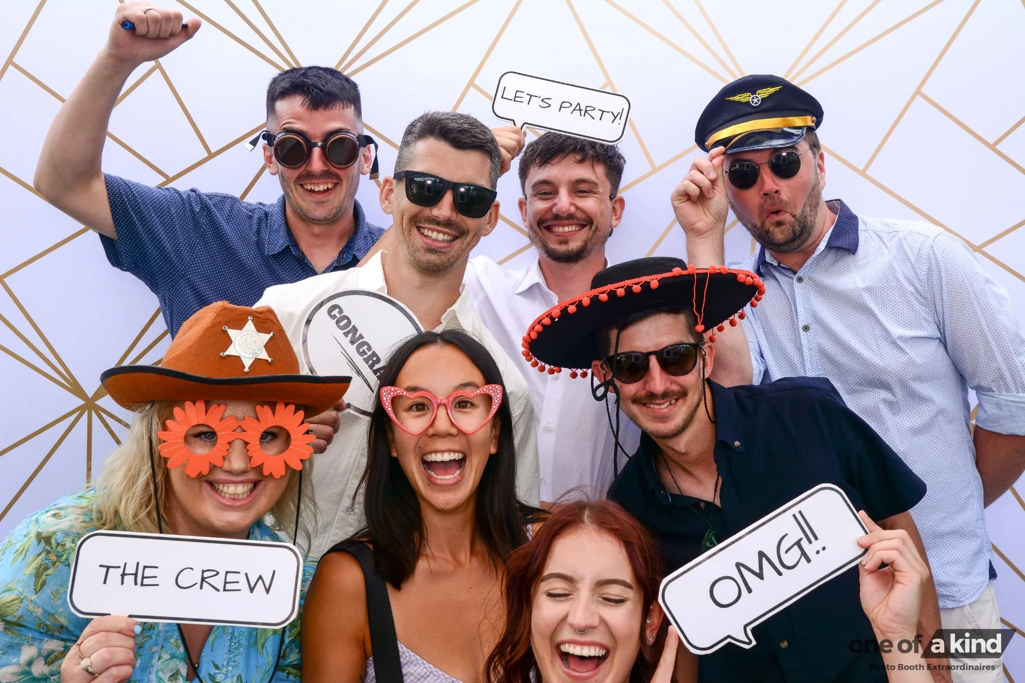 Friends laughing together with photo booth props at an event