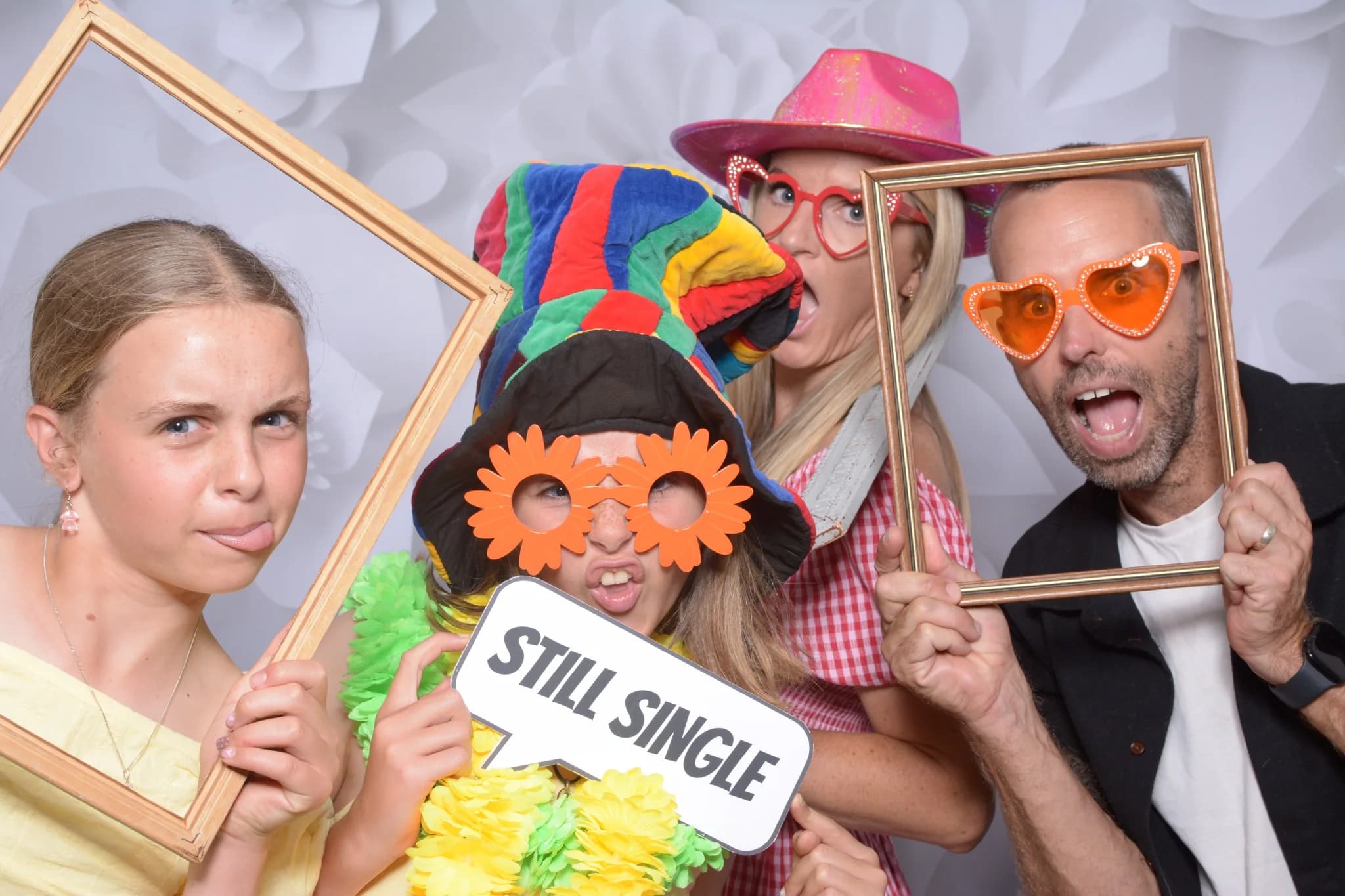 A group of guests posing with a large frame