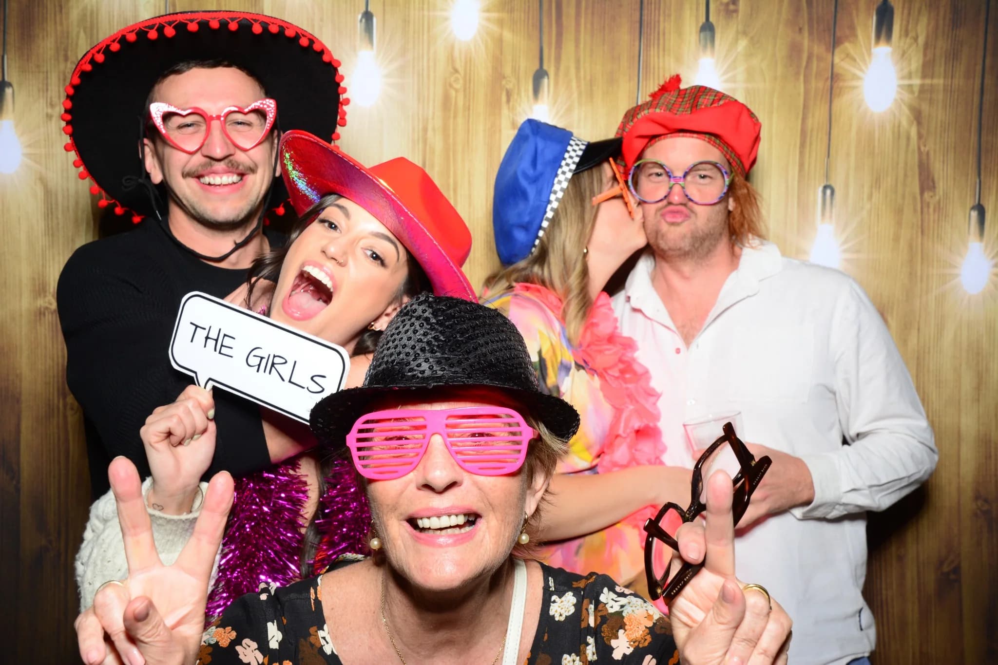 Friends enjoying a party photo booth with hats and glasses